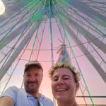 happy couple in front of a ferris wheel